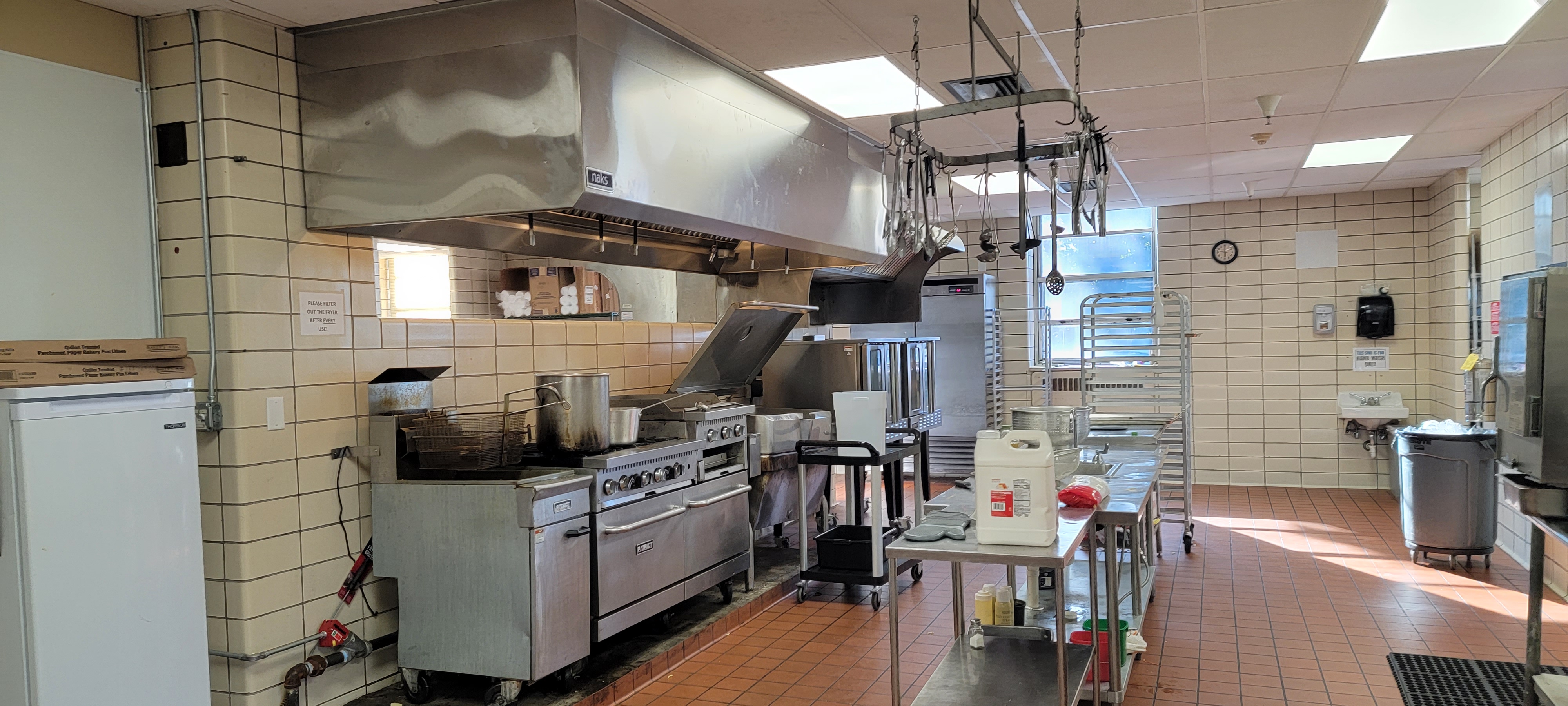 Commercial kitchen equipment, preparation areas and a ventilation hood.