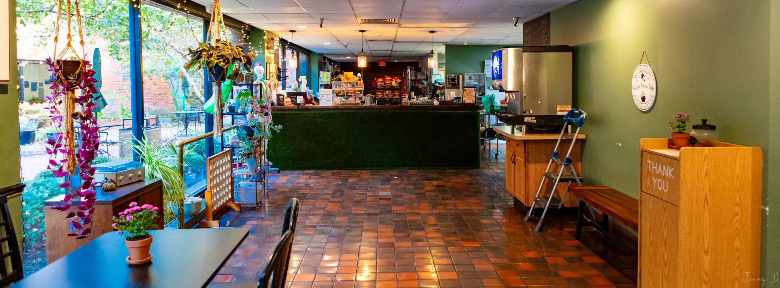 The St. Joseph Café interior with its coffee counter, brick floor and windows facing the courtyard.